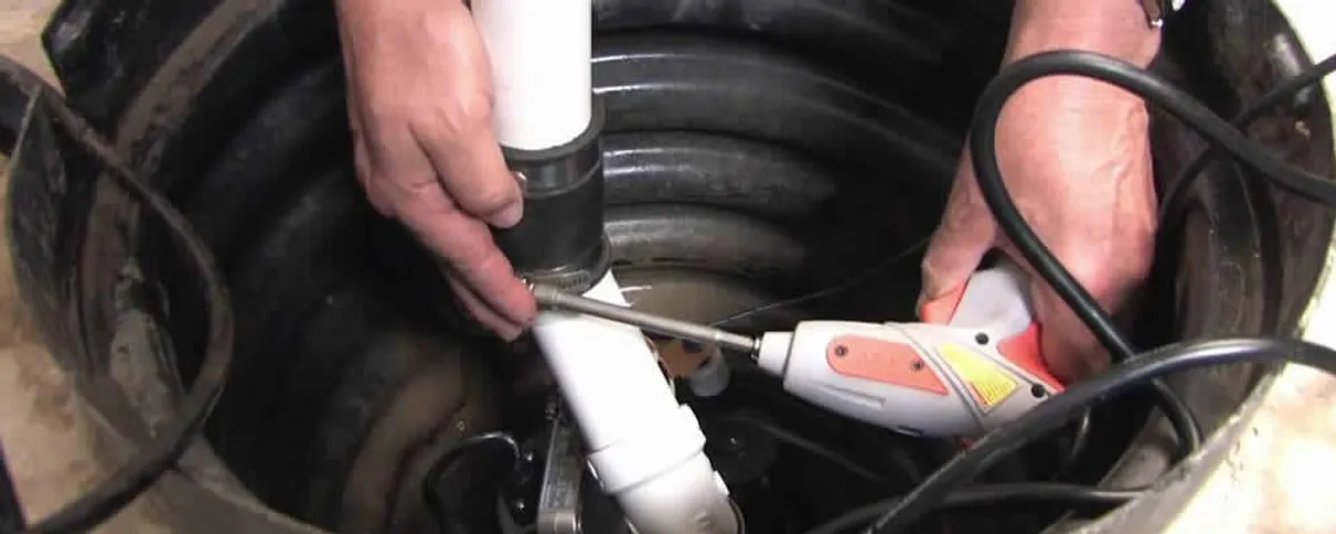 Sump pump installation technician connecting PVC discharge piping in Long Beach, CA